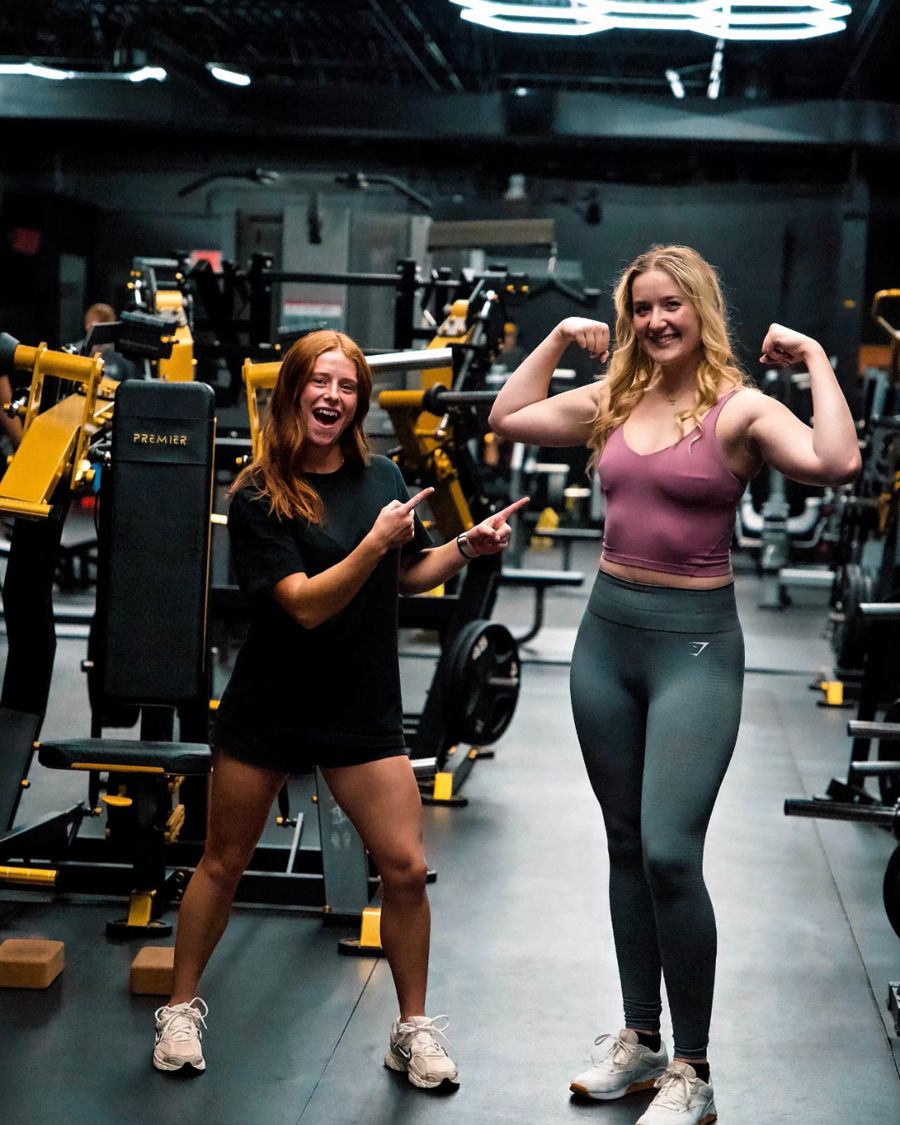 Two clients celebrating and flexing in the Calibrated Strength gym